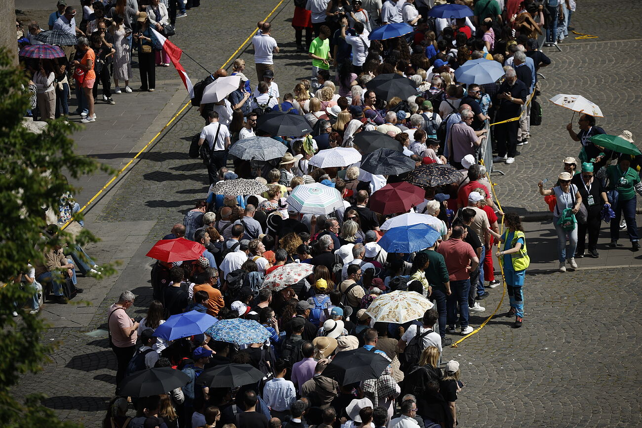 La gente espera protegiéndose del sol