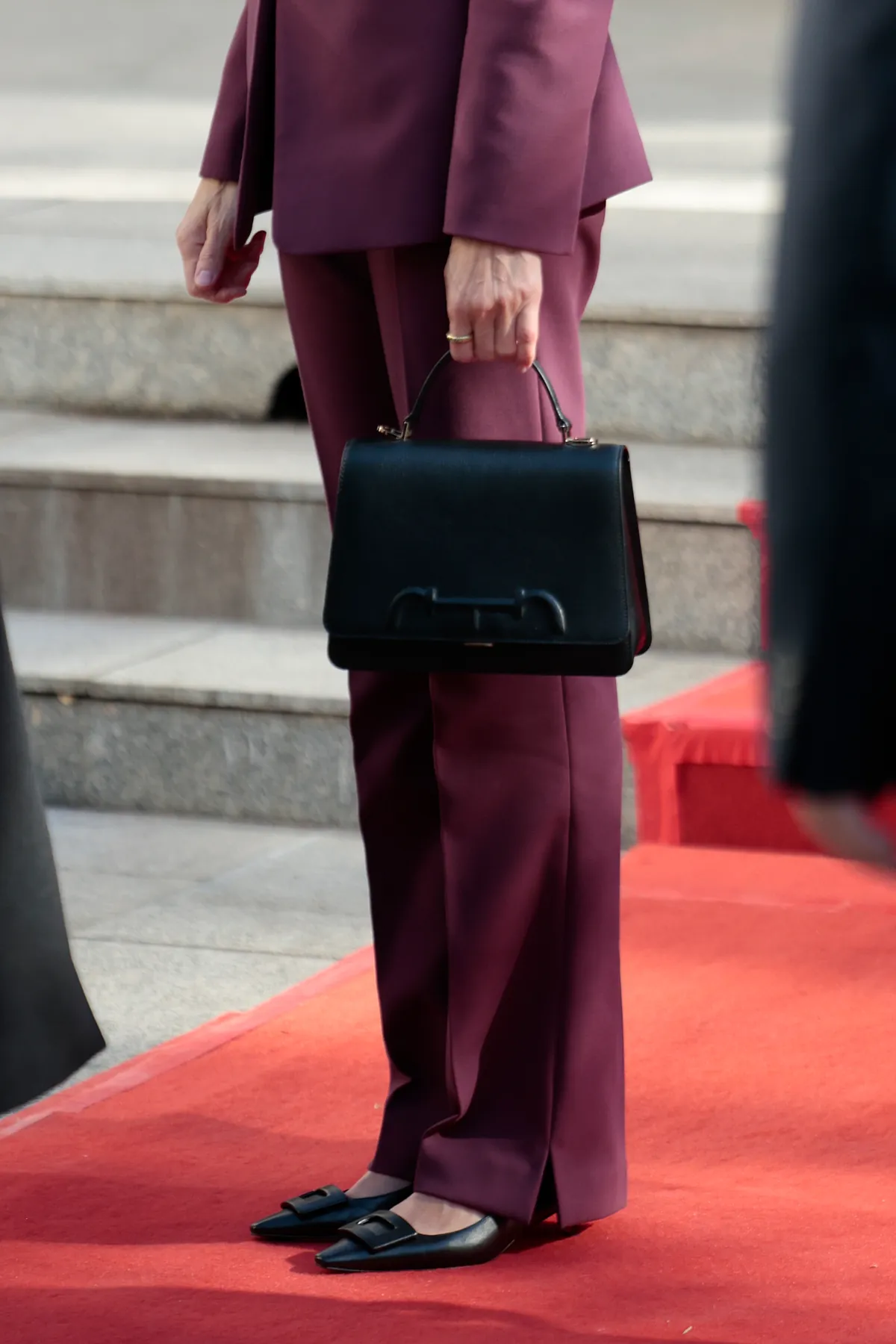 La Reina Letizia apuesta por un traje de chaqueta burdeos en uno de sus últimos actos del Viaje de Estado a China