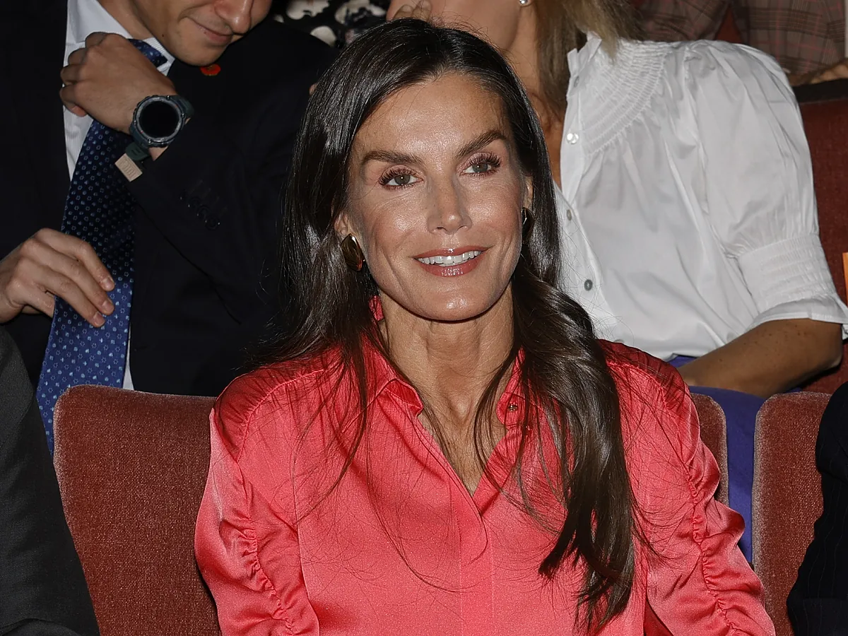 La Reina Letizia con falda de cuero y blusa coral y Sara Carbonero de negro o cómo interpretar un look monocolor de maneras totalmente opuestas