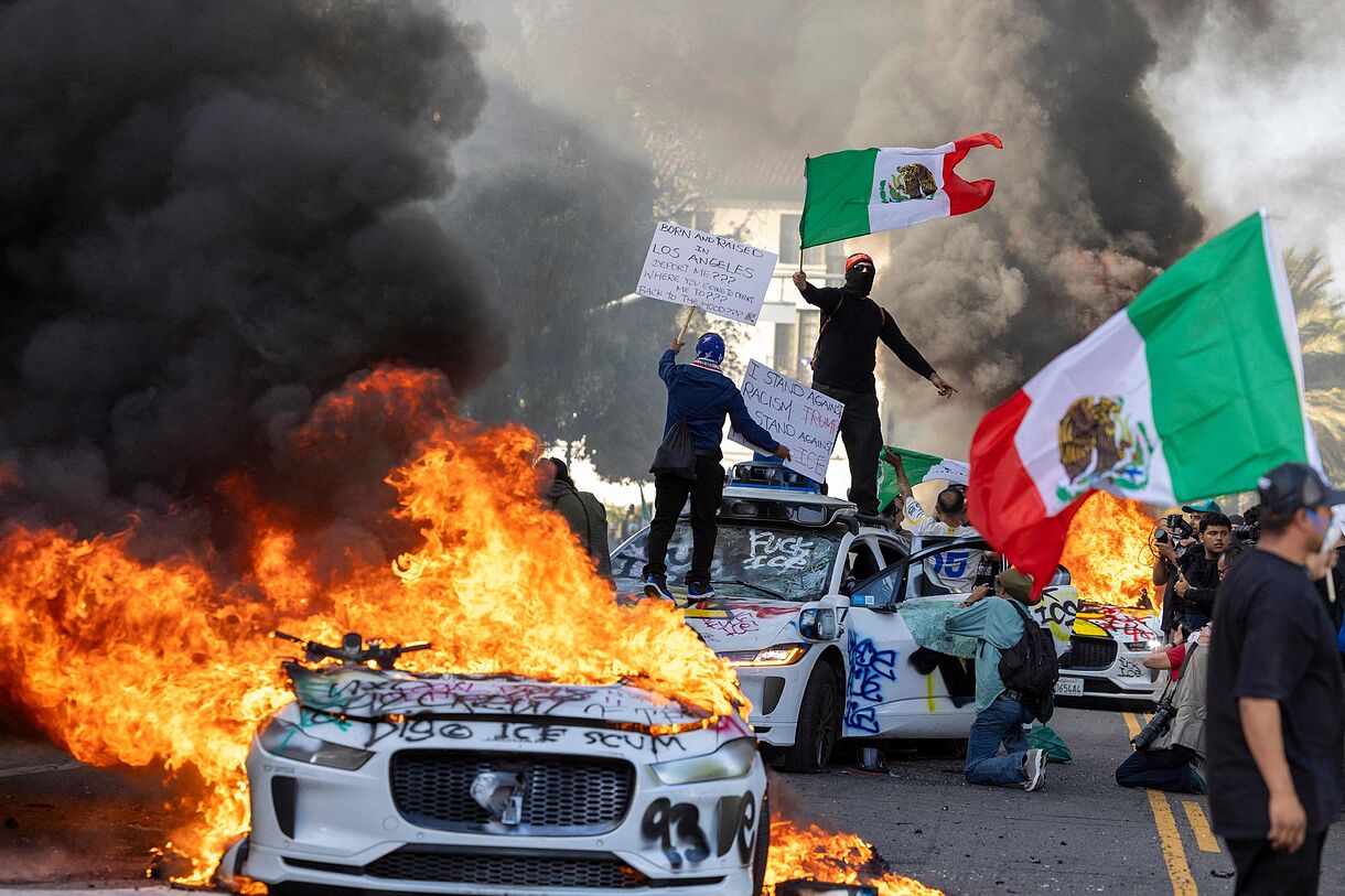 LA Raids: National Guard & Trump Response Protesters and burning cars in Los Angeles.